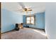 Light-blue bedroom with carpet features a window, ceiling fan and a small crib at 1505 Ozora Rd, Loganville, GA 30052