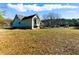 Exterior view of a home with large yard and mature trees on a sunny day at 1505 Ozora Rd, Loganville, GA 30052