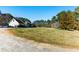 Gravel drive leading to country home with large grassy front yard at 1505 Ozora Rd, Loganville, GA 30052