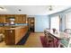 Bright kitchen with wooden cabinets, an eat-in dining area, and a view into the laundry room at 1505 Ozora Rd, Loganville, GA 30052