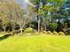 Beautiful backyard featuring lush lawn, mature trees, and manicured landscaping at 3585 Shepherds Ln, Loganville, GA 30052