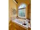 Soaking tub by stained glass window in bathroom at 3585 Shepherds Ln, Loganville, GA 30052