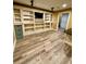 Living room area featuring modern vinyl flooring, built-in shelves and lighting at 3585 Shepherds Ln, Loganville, GA 30052