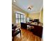 Well-lit office space featuring a large desk, hardwood flooring, and traditional decor at 3585 Shepherds Ln, Loganville, GA 30052