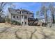 A view of the rear exterior with a large yard, deck with stairs, and mature trees at 10815 Donamere Dr, Johns Creek, GA 30022