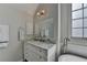Bright bathroom featuring marble countertop vanity, large mirror, and ample cabinet space at 10815 Donamere Dr, Johns Creek, GA 30022