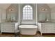 A luxurious bathroom with a soaking tub, dual vanities, and an arched window for natural light at 10815 Donamere Dr, Johns Creek, GA 30022