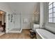 Spacious bathroom with a glass-enclosed shower, soaking tub, and wood-look tile flooring at 10815 Donamere Dr, Johns Creek, GA 30022