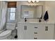 Bright bathroom featuring double vanity with black hardware, hexagon tile floor, and large mirror at 10815 Donamere Dr, Johns Creek, GA 30022