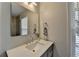 Bathroom featuring a single sink vanity and a view into tiled shower behind glass at 10815 Donamere Dr, Johns Creek, GA 30022