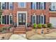 Inviting brick home entrance with black door, tidy landscaping, and classic architectural details at 10815 Donamere Dr, Johns Creek, GA 30022