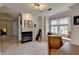 Cozy living room features a fireplace, large window seat, and neutral color palette at 10815 Donamere Dr, Johns Creek, GA 30022