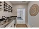 Wine bar with black marble counters, wine fridge, and artistic wine bottle display on the wall at 10815 Donamere Dr, Johns Creek, GA 30022