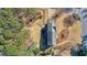 Aerial shot of the home showcasing its roof, landscaping, and a fire pit area amidst the trees at 2805 Roxburgh Dr, Roswell, GA 30076