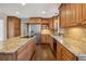 This kitchen has wood cabinets, an island with granite countertop, and stainless steel appliances at 2805 Roxburgh Dr, Roswell, GA 30076