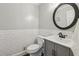 A small powder room features a pedestal sink, round mirror, and tiled wainscoting at 2805 Roxburgh Dr, Roswell, GA 30076