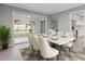 Elegant dining room with a modern table set, leading to a sunroom and featuring wood-look floors at 3236 Henderson Mill Rd, Atlanta, GA 30341