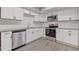 Modern kitchen with white cabinetry, stainless steel appliances, granite countertops, and wood-look flooring at 3236 Henderson Mill Rd, Atlanta, GA 30341