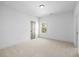 Well-lit bedroom with large window, neutral carpet, and a grey door at 3255 Hilltop Cir, Marietta, GA 30066