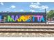 Colorful 'Marietta' mural painted on a building, located near train tracks and urban environment at 3255 Hilltop Cir, Marietta, GA 30066