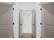 Hallway featuring neutral walls and trim with white doors and dark hardware at 3255 Hilltop Cir, Marietta, GA 30066
