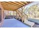 Covered outdoor patio featuring wooden stairs, a concrete slab, and wooded backyard at 3255 Hilltop Cir, Marietta, GA 30066