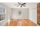 Charming bedroom with hardwood floors, two bright windows, and a rustic wooden accent wall at 60 Collins Rd, Carrollton, GA 30116