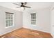 Bright bedroom with hardwood floors, two windows, and a ceiling fan for added comfort at 60 Collins Rd, Carrollton, GA 30116