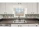 Modern kitchen sink with neutral backsplash and white cabinetry at 60 Collins Rd, Carrollton, GA 30116
