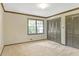 Bright bedroom with closet doors, neutral carpet, and a large window for natural light at 1559 Norwood Dr, Lilburn, GA 30047