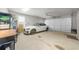 Spacious garage featuring a white sports car, storage shelves, and an automatic garage door at 1605 Camden Cove Dr, Cumming, GA 30040