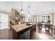 Open kitchen layout with island seating and view to the fireplace at 1605 Camden Cove Dr, Cumming, GA 30040