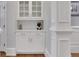 Stylish bar with white cabinets, subway tile backsplash, and marble countertop at 4992 Price Dr, Suwanee, GA 30024