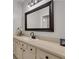 Bathroom featuring large framed mirror, white cabinets with dark hardware, and neutral countertops at 4992 Price Dr, Suwanee, GA 30024