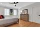 This is a bedroom with a wooden bed and floors and a wooden set of drawers at 4992 Price Dr, Suwanee, GA 30024