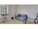 Bonus room with comfortable blue sofa and instruments like guitars and a keyboard at 4992 Price Dr, Suwanee, GA 30024
