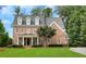 Charming two-story brick home with a manicured lawn, black door, and a welcoming front porch at 4992 Price Dr, Suwanee, GA 30024