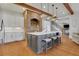 Modern kitchen with gray island, exposed brick, stainless steel appliances, and hardwood floors at 4992 Price Dr, Suwanee, GA 30024