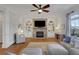 Well lit living room with fireplace, built-ins, and area rug at 4992 Price Dr, Suwanee, GA 30024