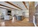 Open-concept living area with stone fireplace, wood beams, and island with stainless steel appliances at 4992 Price Dr, Suwanee, GA 30024