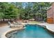Relaxing backyard oasis featuring a beautiful pool, spa with waterfall, and ample lounging space at 4992 Price Dr, Suwanee, GA 30024