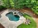 An aerial view showcases a sparkling pool and spa, surrounded by lush landscaping, lounge chairs, and a fire pit at 4992 Price Dr, Suwanee, GA 30024