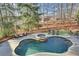 Inviting backyard oasis featuring a gunite pool, spa, lounge chairs, and mature trees for privacy at 4992 Price Dr, Suwanee, GA 30024