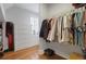 This is a walk-in closet with a clothing rack, a wooden floor, and a white set of drawers at 4992 Price Dr, Suwanee, GA 30024