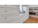 This is a walk-in closet with a set of white drawers with a mirror and a shelf for shoes at 4992 Price Dr, Suwanee, GA 30024