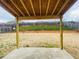 Covered patio with view of large backyard, wooden fence, and retaining wall with a grassy hill at 1159 Fort Marcy Park, Lawrenceville, GA 30044