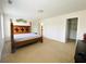 Spacious bedroom featuring carpet, large four-poster bed, neutral walls, and a walk-in closet at 1159 Fort Marcy Park, Lawrenceville, GA 30044