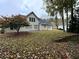 Backyard view showcasing a spacious lawn, mature trees, and partial view of the house at 2020 Wynfield Point Dr, Buford, GA 30519