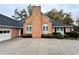 Close up of a well-maintained brick facade with a black roof, contrasted by neat landscaping at 2020 Wynfield Point Dr, Buford, GA 30519