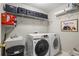 Well-organized laundry room featuring a utility sink, modern washer and dryer, and ample storage shelving at 1211 Promontory Path, Marietta, GA 30062